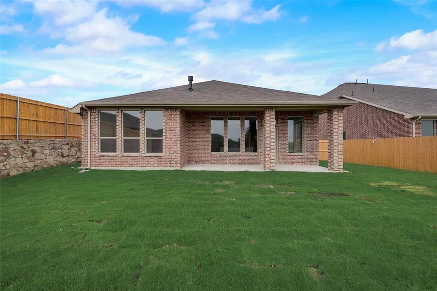 Rear view of house with a patio area and a lawn