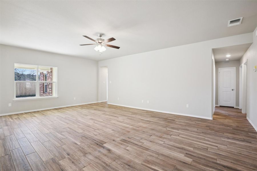 Spare room with light wood finished floors and ceiling fan