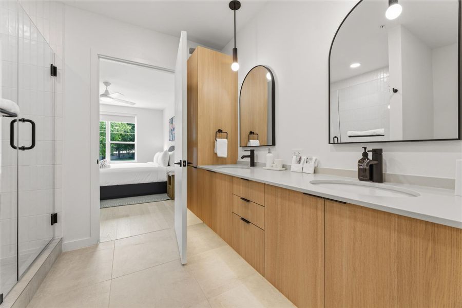 Clean lines and light wood cabinetry define this modern dual-sink bathroom. Clean lines and light wood cabinetry define this modern dual-sink bathroom.
