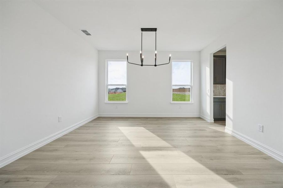 Dining nook off kitchen with large windows. * Model representation.
