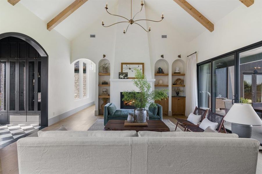 Living room featuring beamed ceiling, high vaulted ceiling, and wood-type flooring