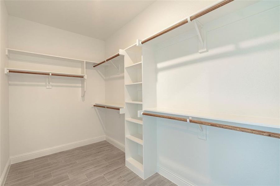 Spacious closet with light hardwood / wood-style floors