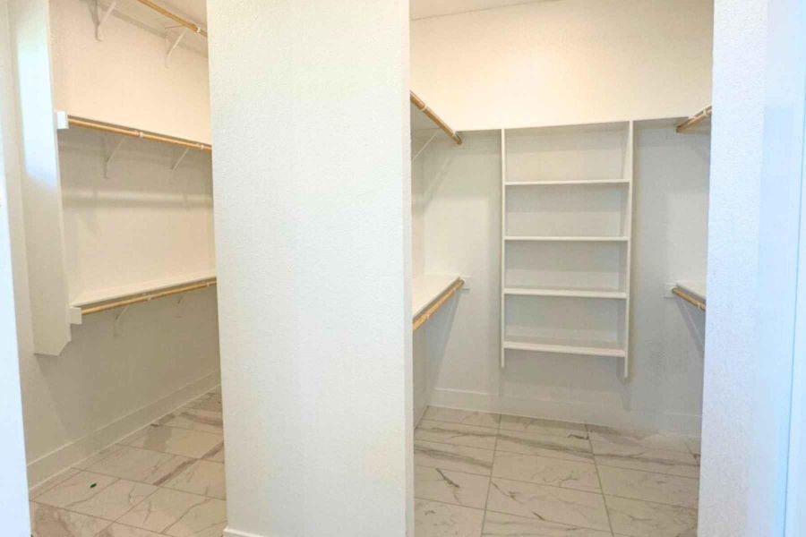 Walk in closet with light marble finish flooring