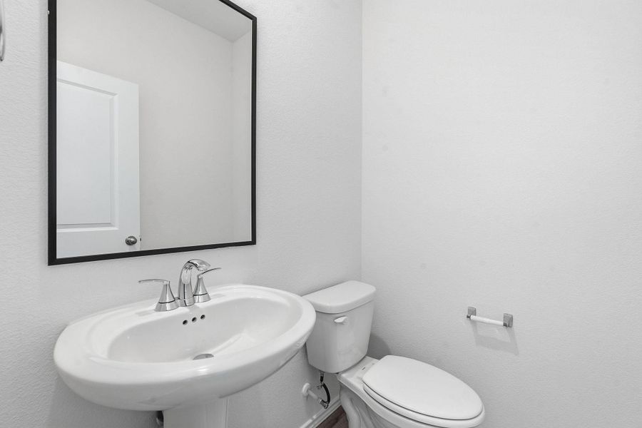 Pedestal sink with chrome faucet set, complemented by a rectangular mirror with a black frame Pedestal sink with chrome faucet set, complemented by a rectangular mirror with a black frame