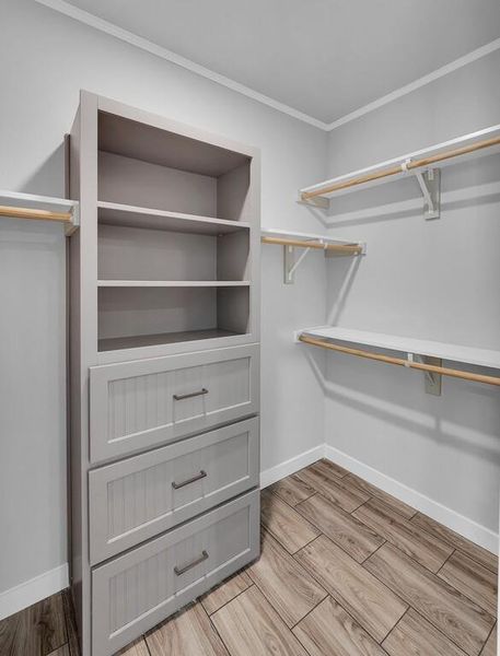 Walk in closet featuring wood finish floors Walk in closet featuring wood finish floors