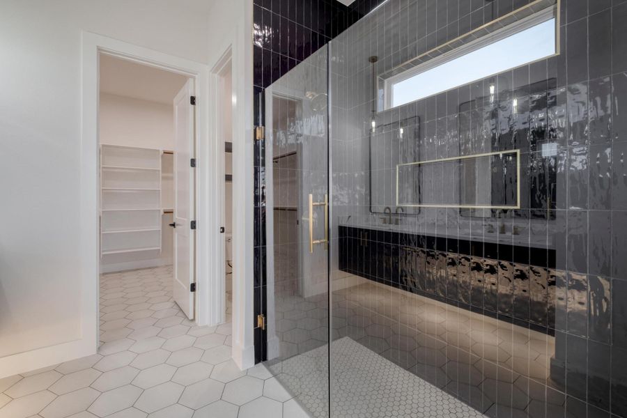 Full bath with tile patterned flooring, a shower stall, and a spacious closet