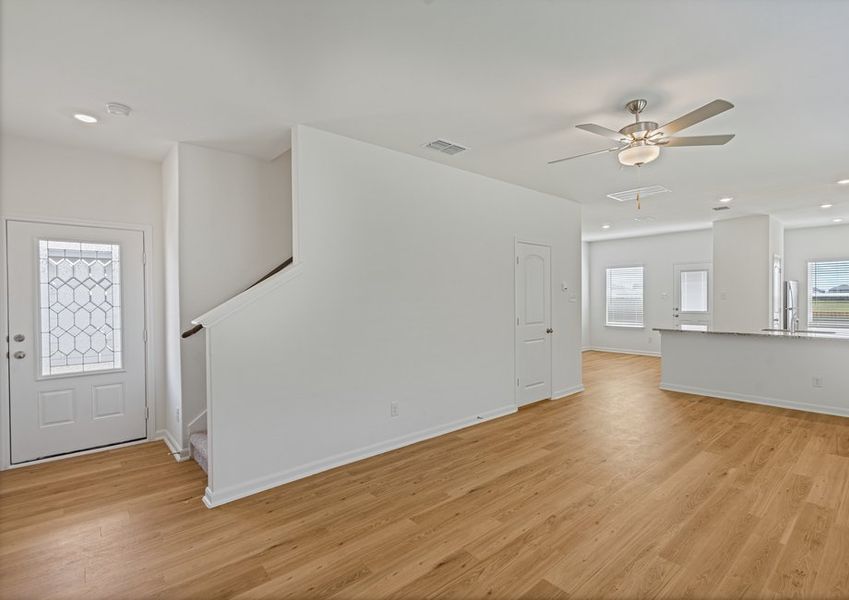 The front door with a staircase and open floor plan