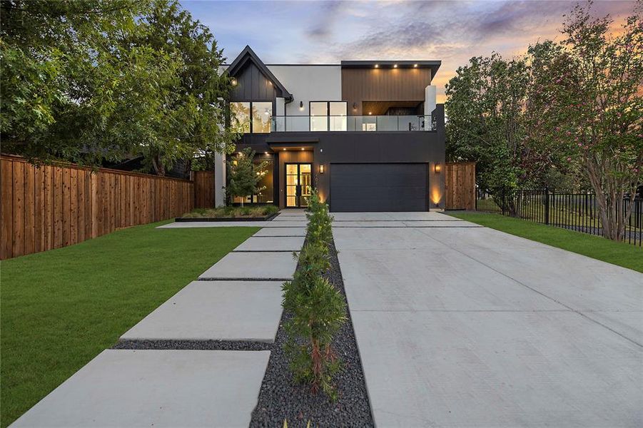 Contemporary house featuring a balcony, concrete driveway, and an attached garage Contemporary house featuring a balcony, concrete driveway, and an attached garage
