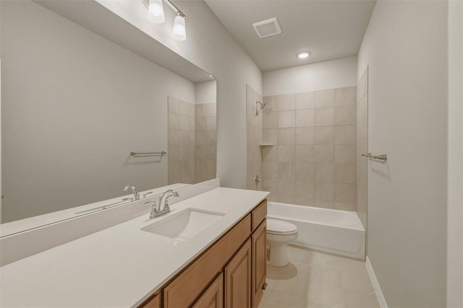 Full bathroom featuring an integrated sink, wood-finish vanity, and a rectangular mirror Full bathroom featuring an integrated sink, wood-finish vanity, and a rectangular mirror