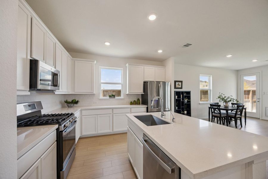 Kitchen with its beautiful quartz counters, gas range and perfect island.