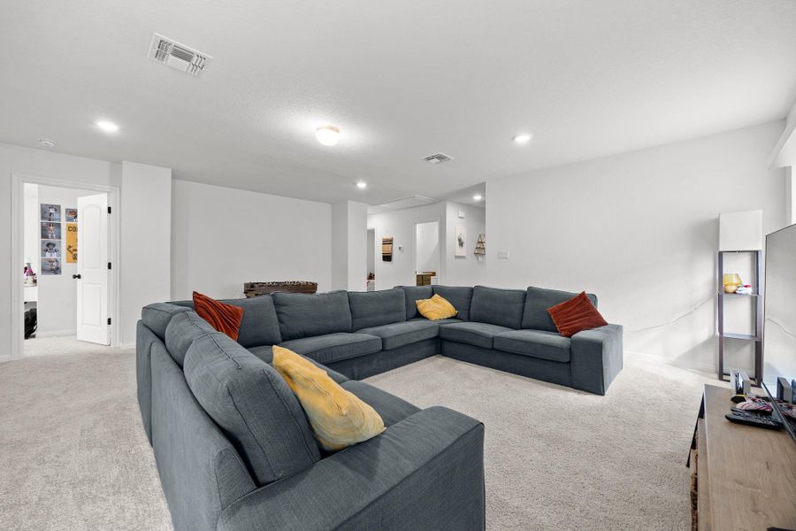 Spacious room featuring light-colored carpet flooring, recessed lighting, and white walls