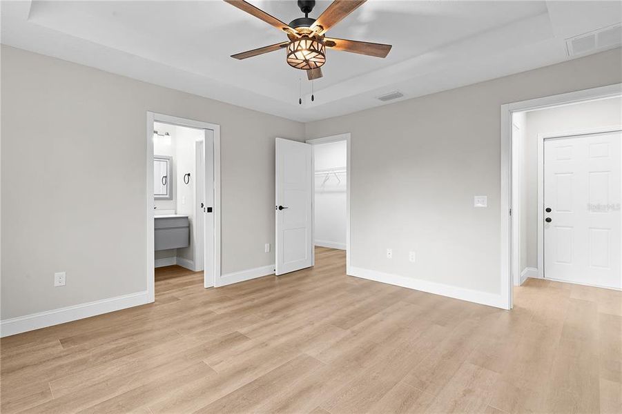 Primary bedroom with ensuite bathroom and walk-in closet in background