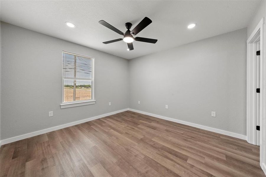 Empty room with ceiling fan, wood finished floors, and recessed lighting Empty room with ceiling fan, wood finished floors, and recessed lighting