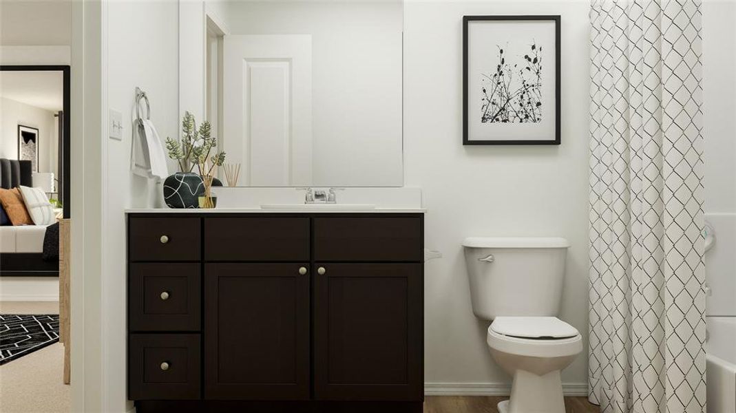 Bathroom with hardwood / wood-style floors, vanity, and toilet