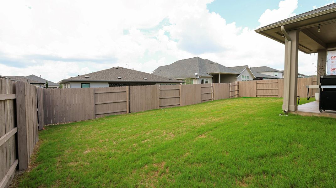 A spacious backyard enclosed by a sturdy wooden fence offers ample privacy and room for recreation. A spacious backyard enclosed by a sturdy wooden fence offers ample privacy and room for recreation.