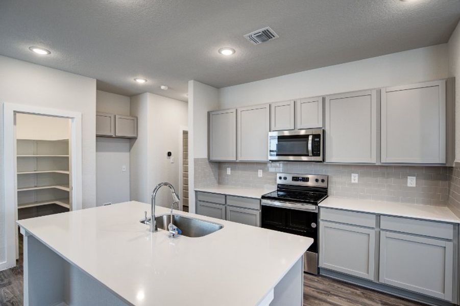 A kitchen with white cabinets.