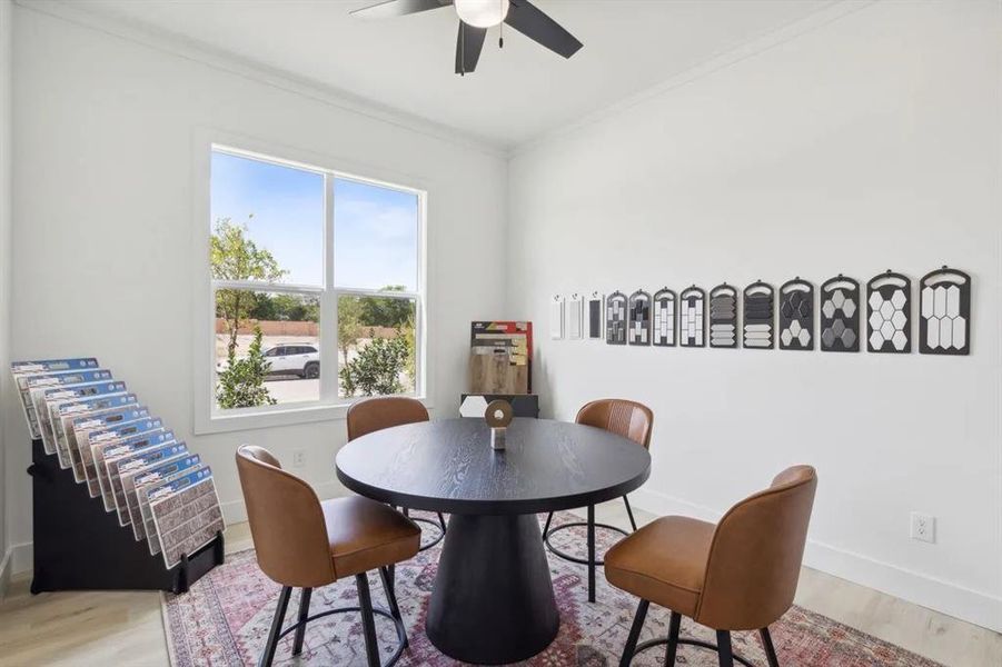 Dining space with wood finished floors, crown molding, and ceiling fan