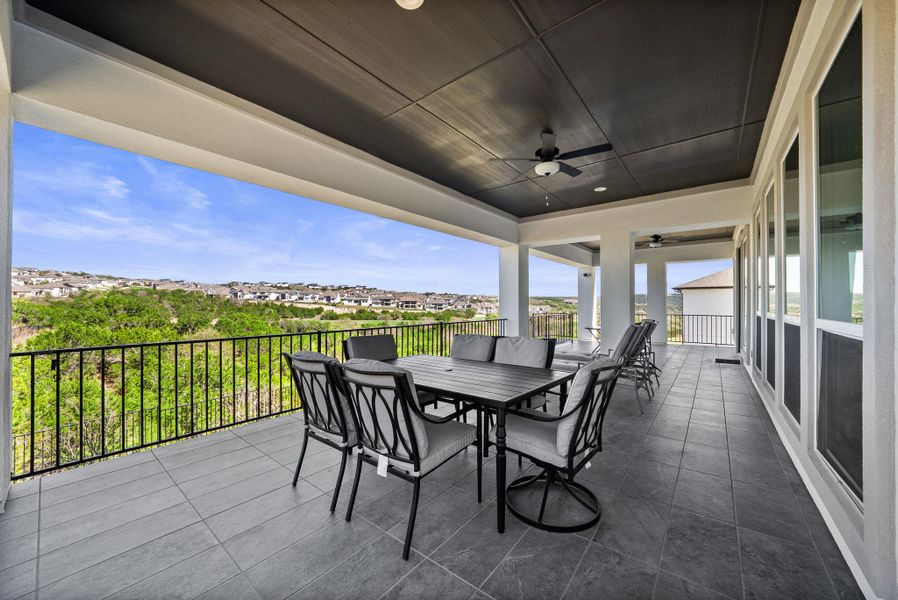 View of patio with a ceiling fan, outdoor dining area, and a residential view