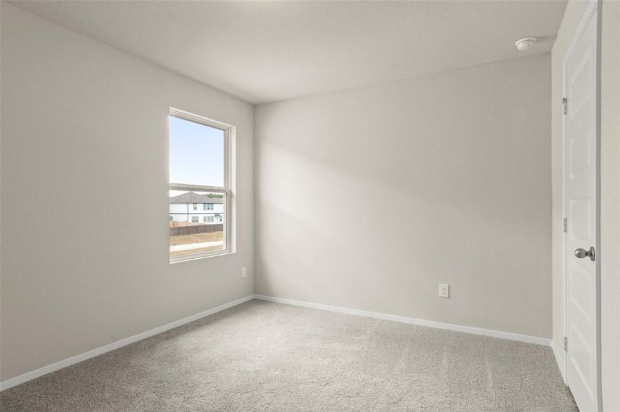 Carpeted spare room featuring baseboards