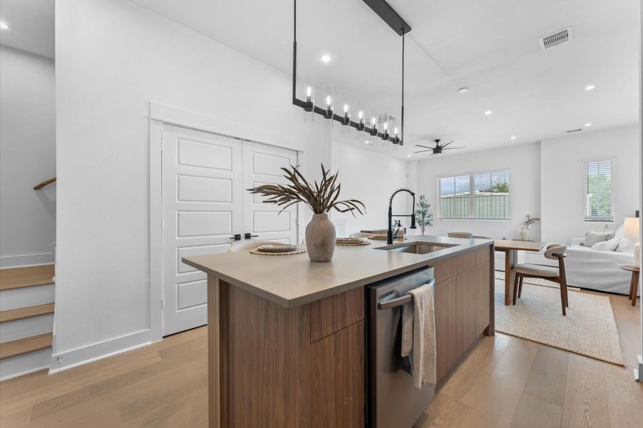 The heart of the second-floor open-concept living, dining, and kitchen, this spacious kitchen island features sleek modern finishes, including a one-sided cascade quartz countertop, a farmhouse sink, and stylish pendant lighting, with a built-in seating area perfect for casual breakfasts or chatting with family and frien