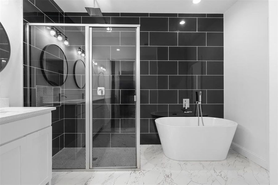 Bathroom with plus walk in shower, vanity, and tile walls