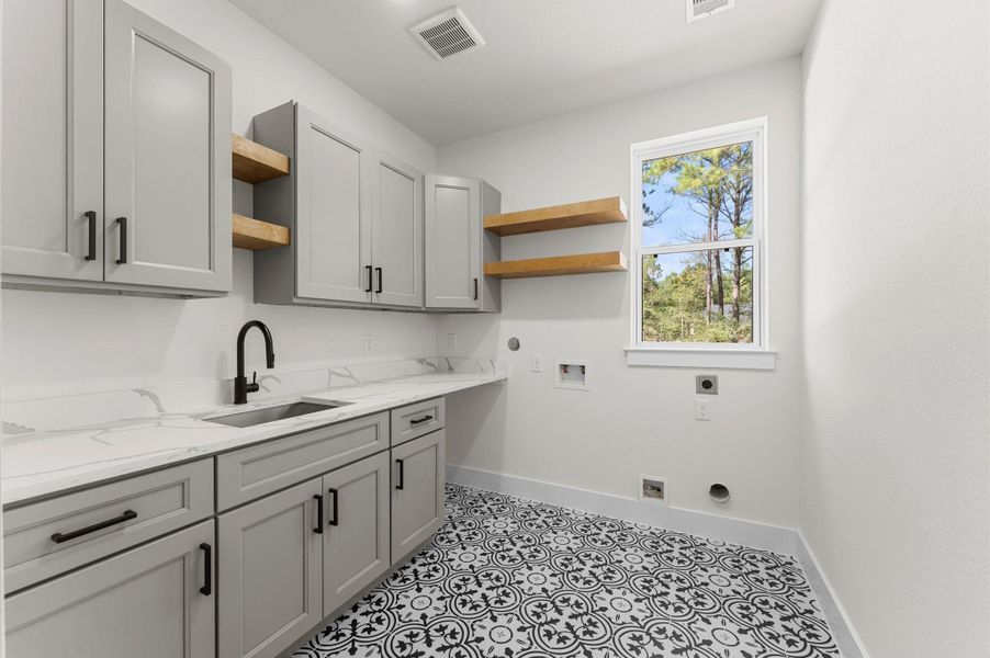 Well-appointed laundry room with built-in cabinets and high-end finishes, offering both style and functionality. Well-appointed laundry room with built-in cabinets and high-end finishes, offering both style and functionality.