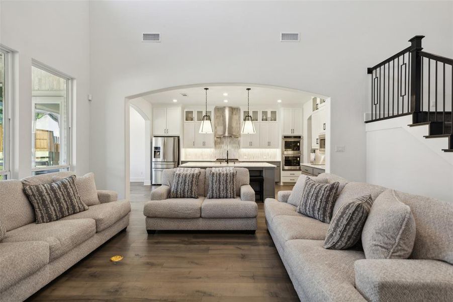 Living room with sink, dark wood-type flooring, and a high ceiling