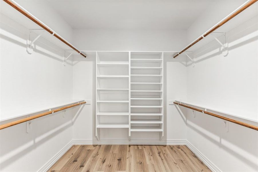 Walk in closet with light wood-type flooring