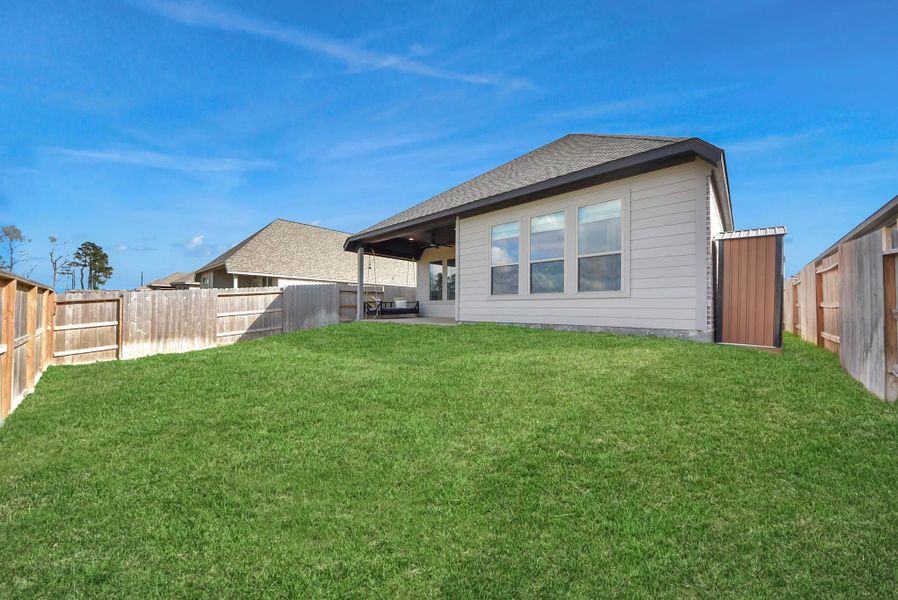 Rear ExteriorThe rear of this modern single-story home showcases a beautifully maintained backyard and a covered patio designed for year-round outdoor enjoyment—perfect for relaxing, entertaining, or family activities.