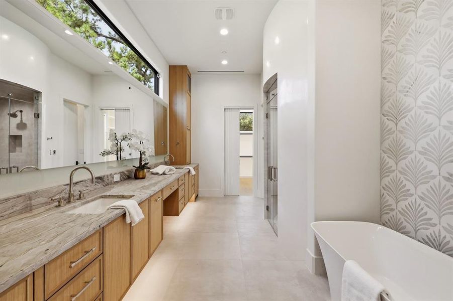Primary bath offers a steam shower, heated tile floors, soaking tub, dual closets and dedicated washer/dryer
