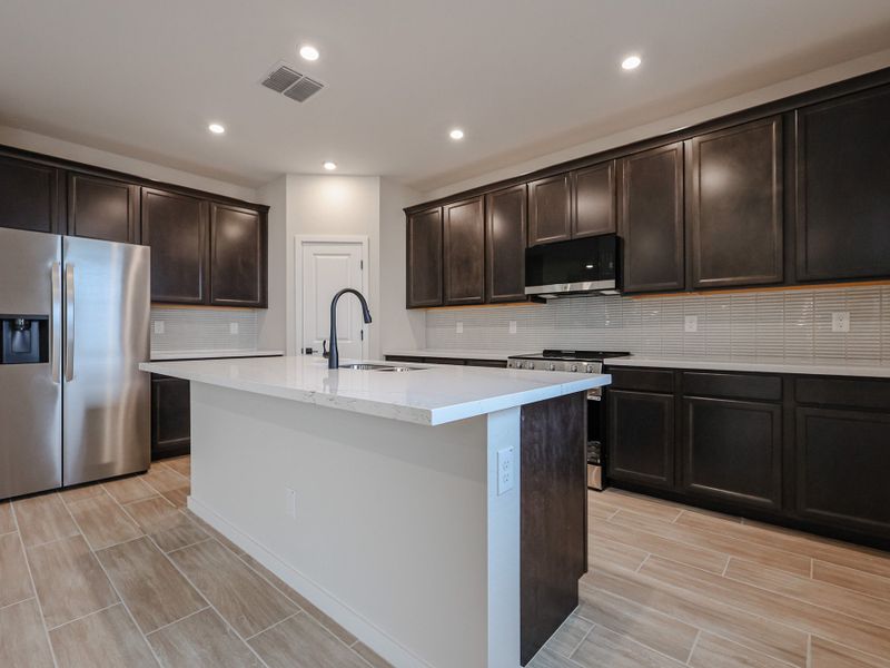 A kitchen with black cabinets.