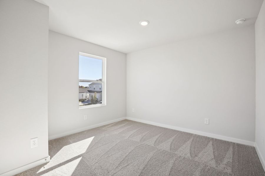 A room with a carpet and a window.