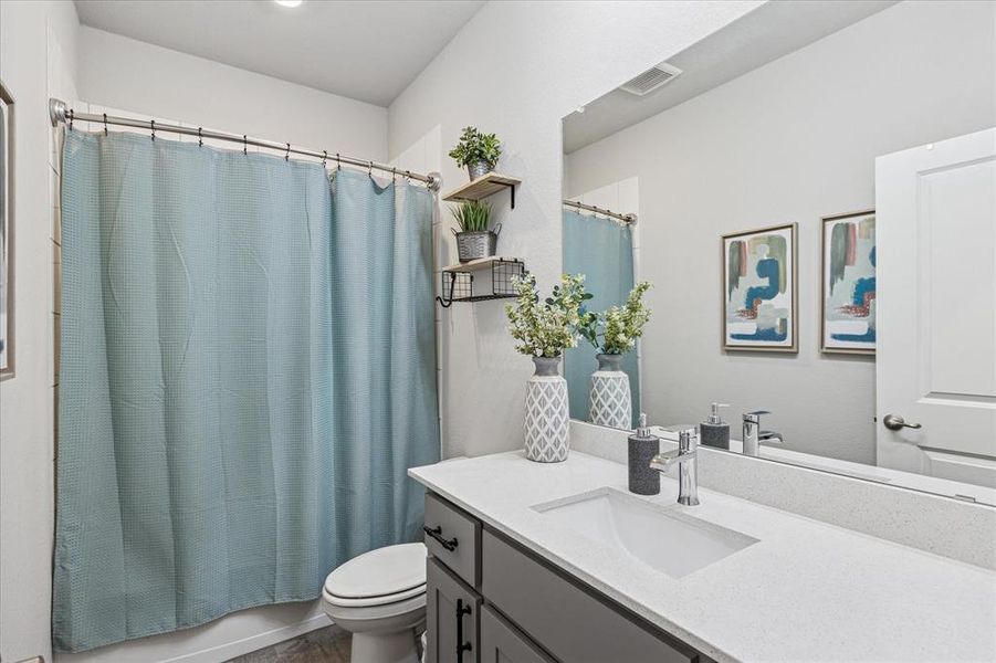 Full bathroom featuring vanity, toilet, shower / bath combination with wood finished floors Full bathroom featuring vanity, toilet, shower / bath combination with wood finished floors