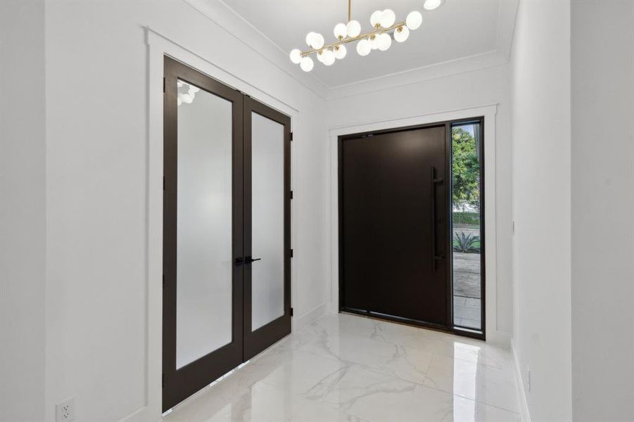 Foyer featuring crown molding and an inviting chandelier