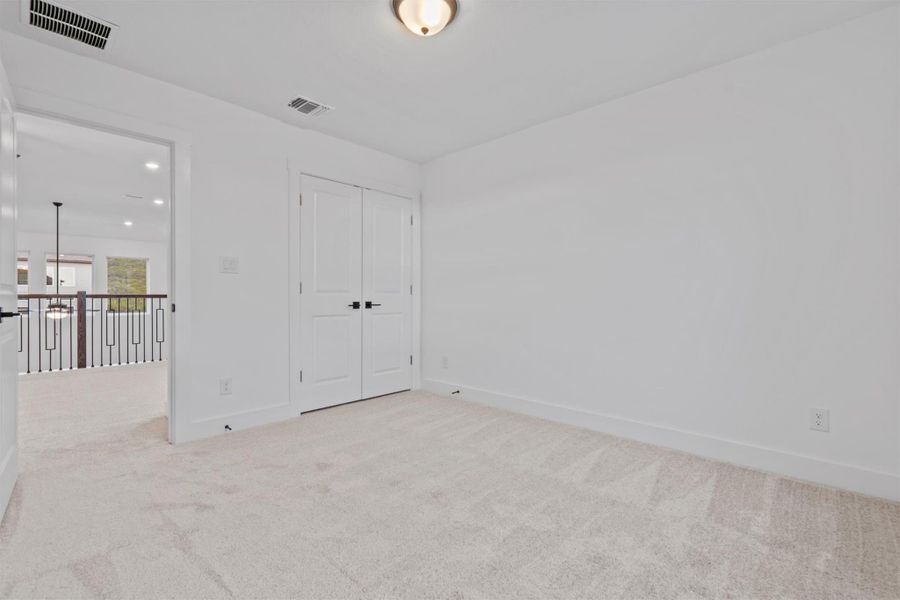 Unfurnished bedroom featuring light colored carpet and a closet