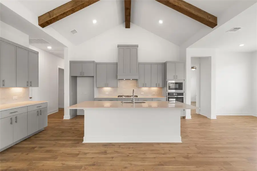 Kitchen showcasing a large central island and modern appliances. Kitchen showcasing a large central island and modern appliances.