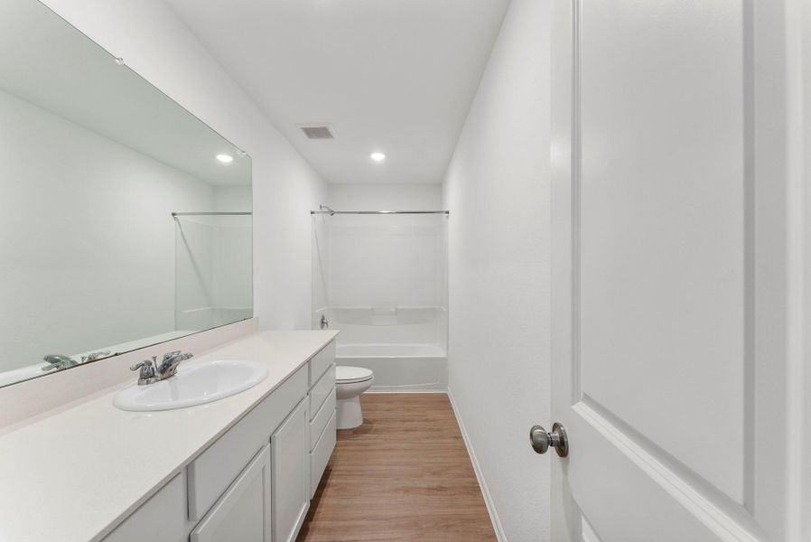 The primary bathroom has ample counter and cabinet space.
