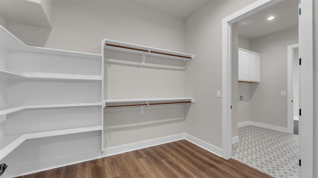 Custom shelving and hanging rods maximize storage in this spacious walk-in closet. Custom shelving and hanging rods maximize storage in this spacious walk-in closet.