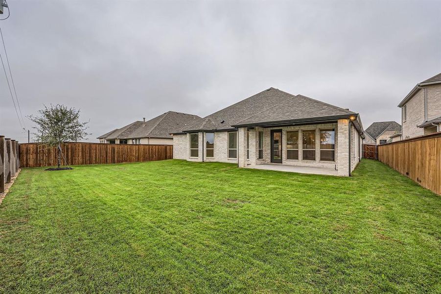 Back of property featuring a lawn and a patio area