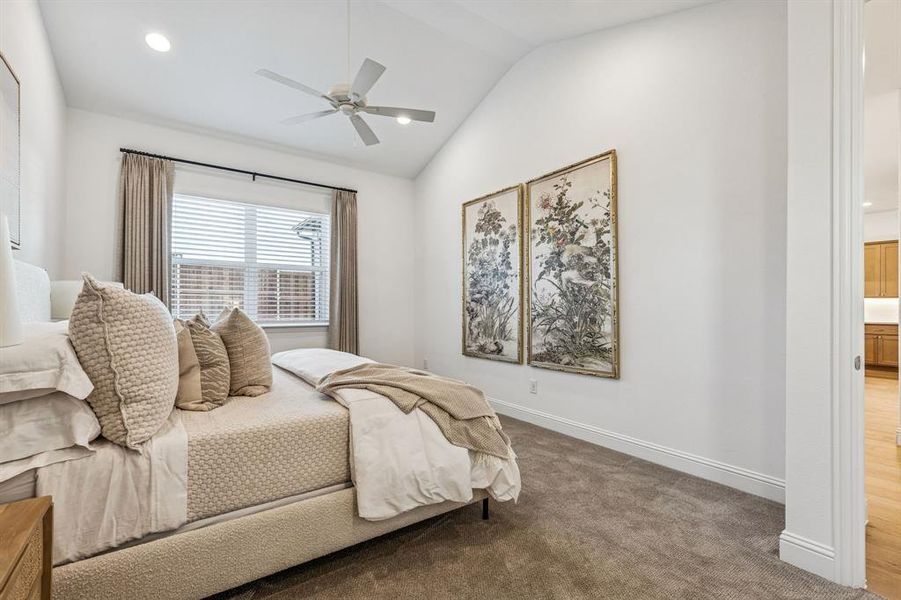 Carpeted bedroom featuring lofted ceiling, a ceiling fan, and recessed lighting