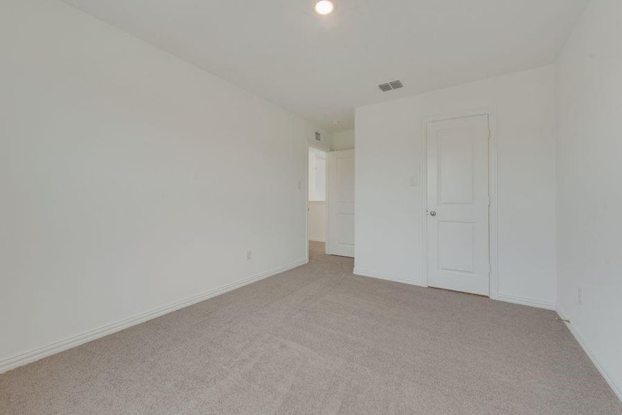 Unfurnished bedroom with light carpet and recessed lighting Unfurnished bedroom with light carpet and recessed lighting