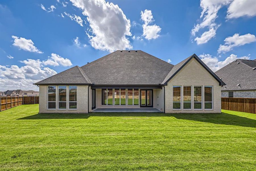 Back of house with a yard and a patio