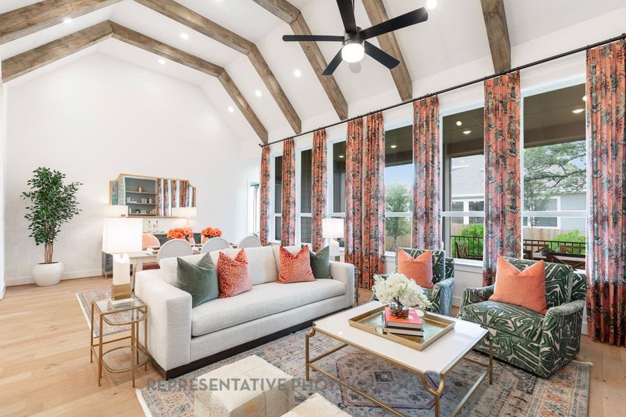 Living area with beam ceiling, wood finished floors, high vaulted ceiling, a ceiling fan, and recessed lighting