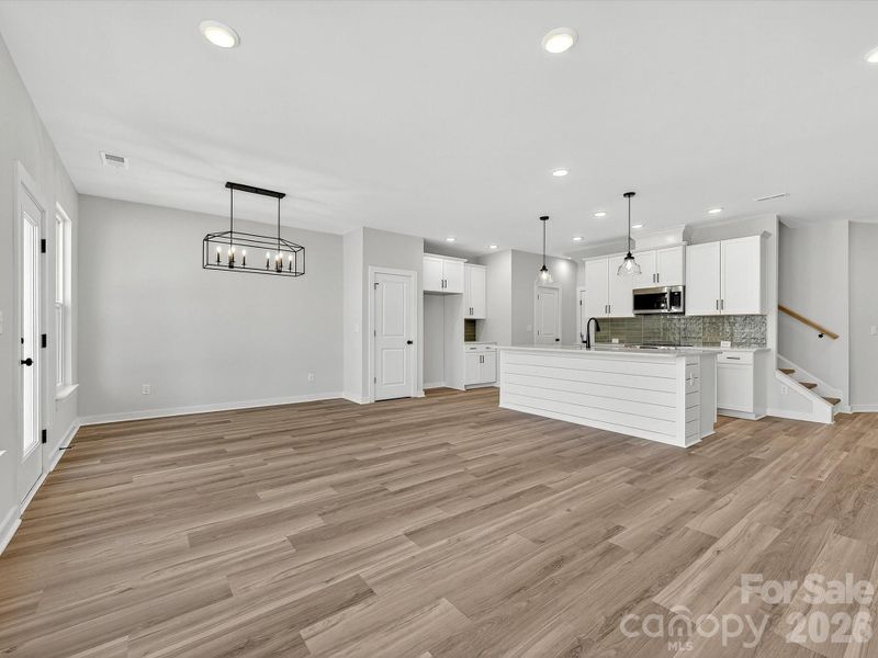 42" White cabinets, Quartz countertops, tiled backsplash. Large kitchen island with shiplap accent, Frigidaire Appliances. Cooking is exhaust vented to the outside