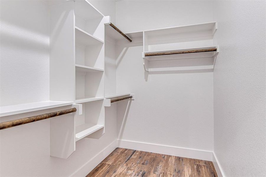 Walk in closet with wood-type flooring