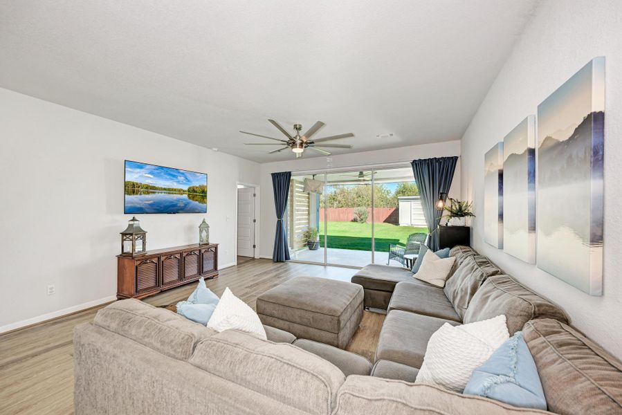 Living room with wood finished floors and a ceiling fan