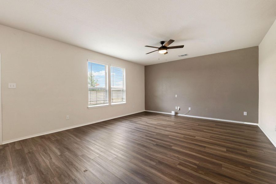 A well-lit living area features warm wood type flooring A well-lit living area features warm wood type flooring