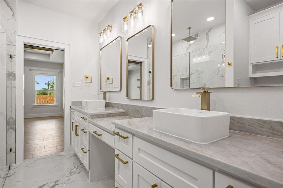 Double vanity with white cabinetry, gold-toned hardware, and rectangular vessel sinks