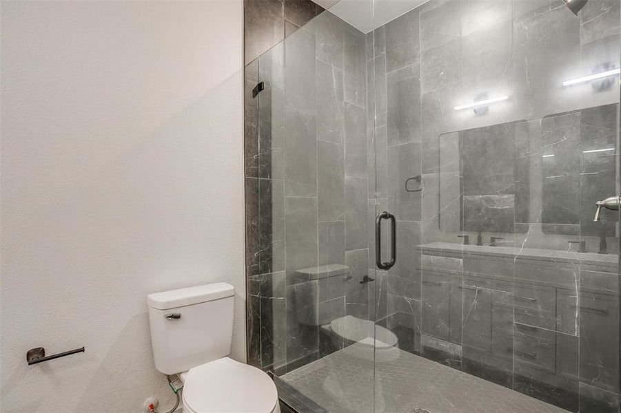 Bathroom featuring toilet and a stall shower