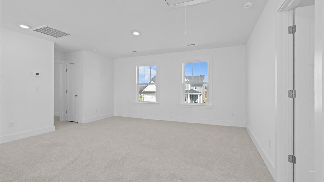Memorable space with walk-in closet, soft carpeting, and striking natural light from large windows